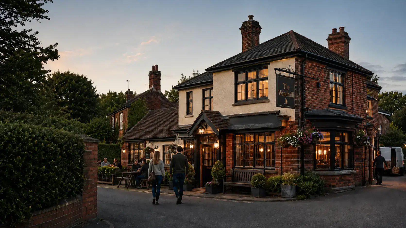 Traditional British pub exterior at dusk with The Windmill sign.