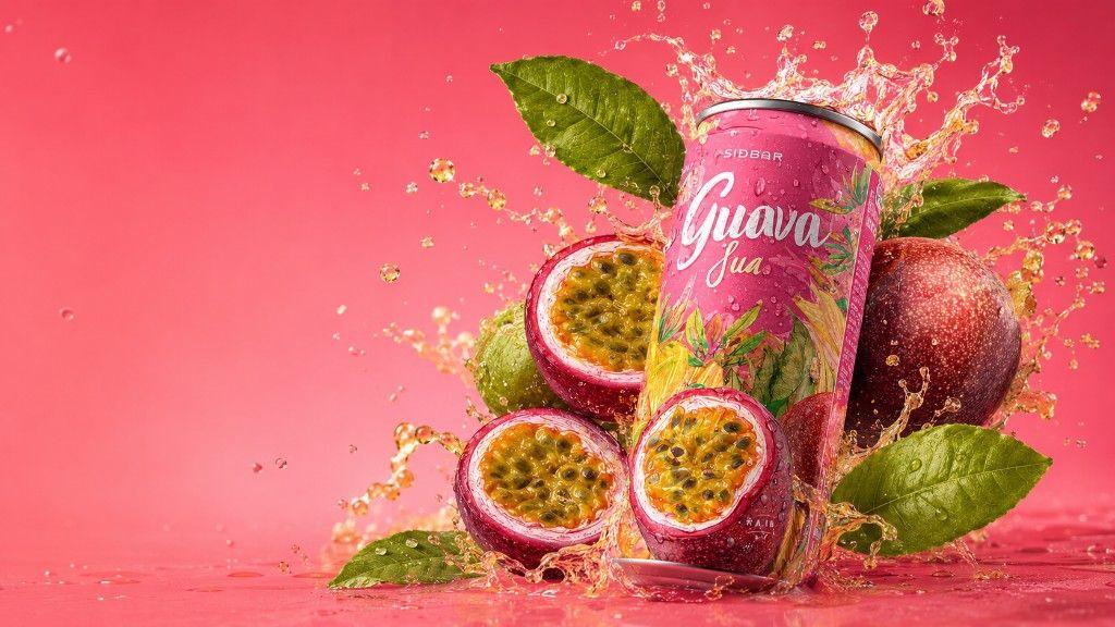 Vibrant summer beverage product photograph: pink aluminium can with condensation, passion fruit halves, tropical leaves, and a golden juice splash on a magenta background — editorial metaphor for peak-season commerce energy.